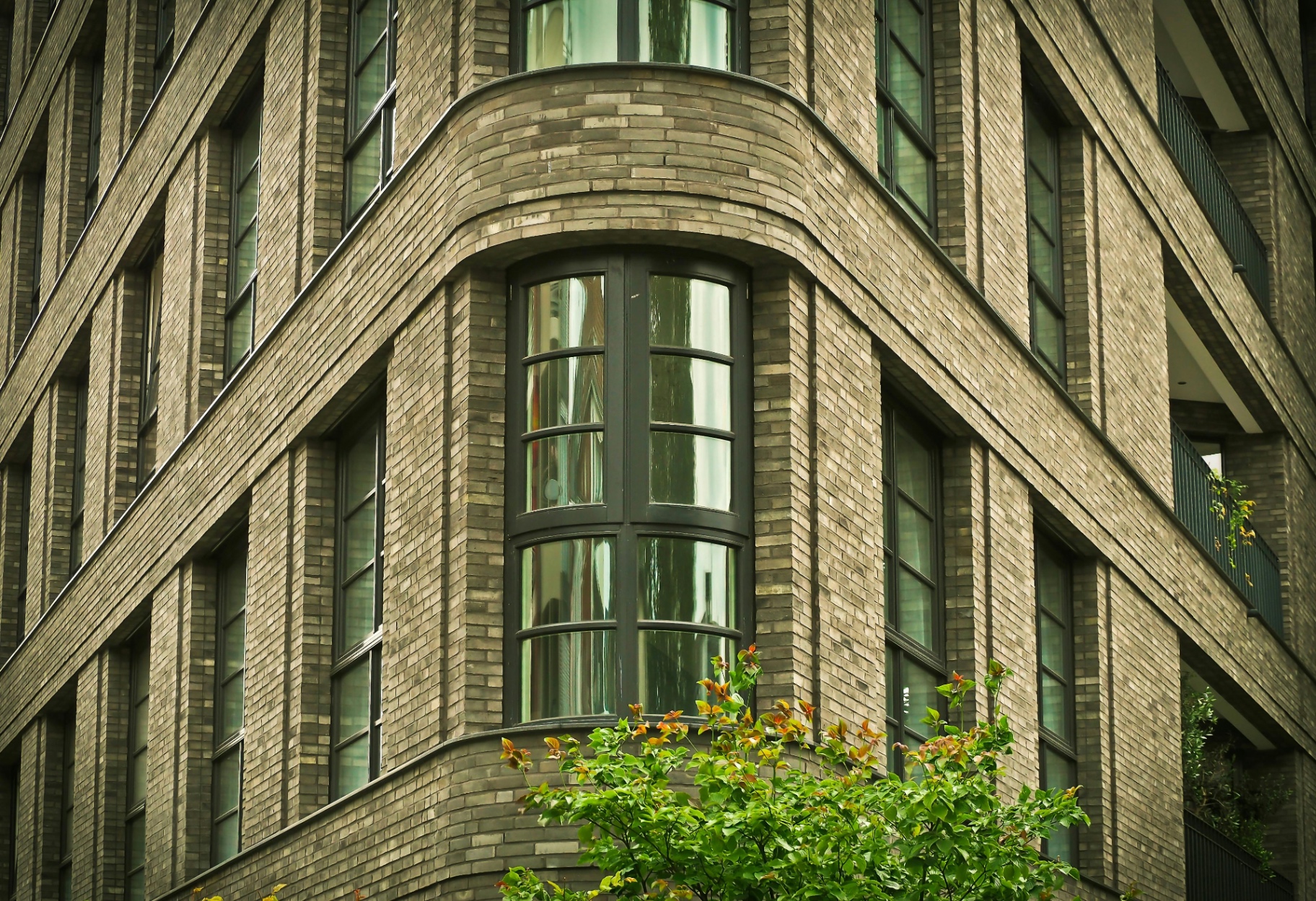 Arched interior revealing a wooden window with flowers on the sill